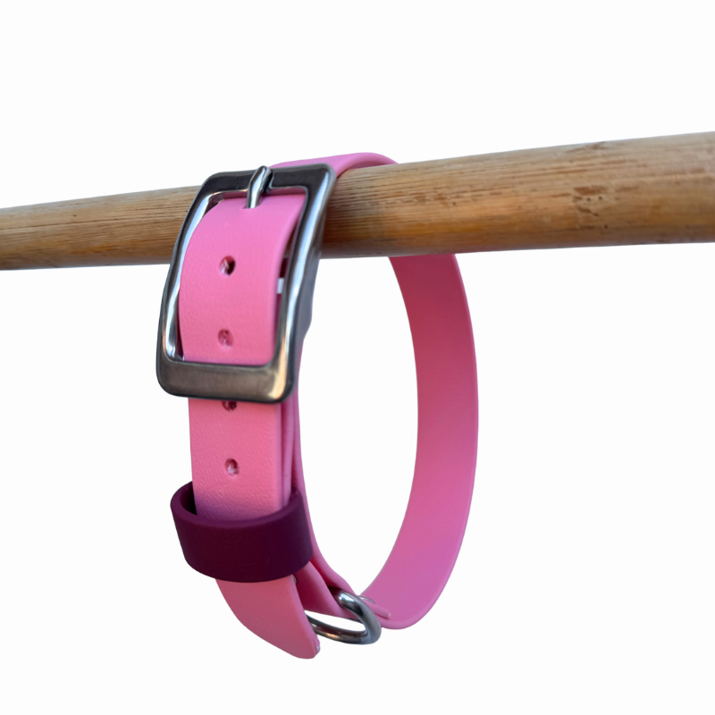Pastel pink Biothane collar on a wooden rod against a white background.